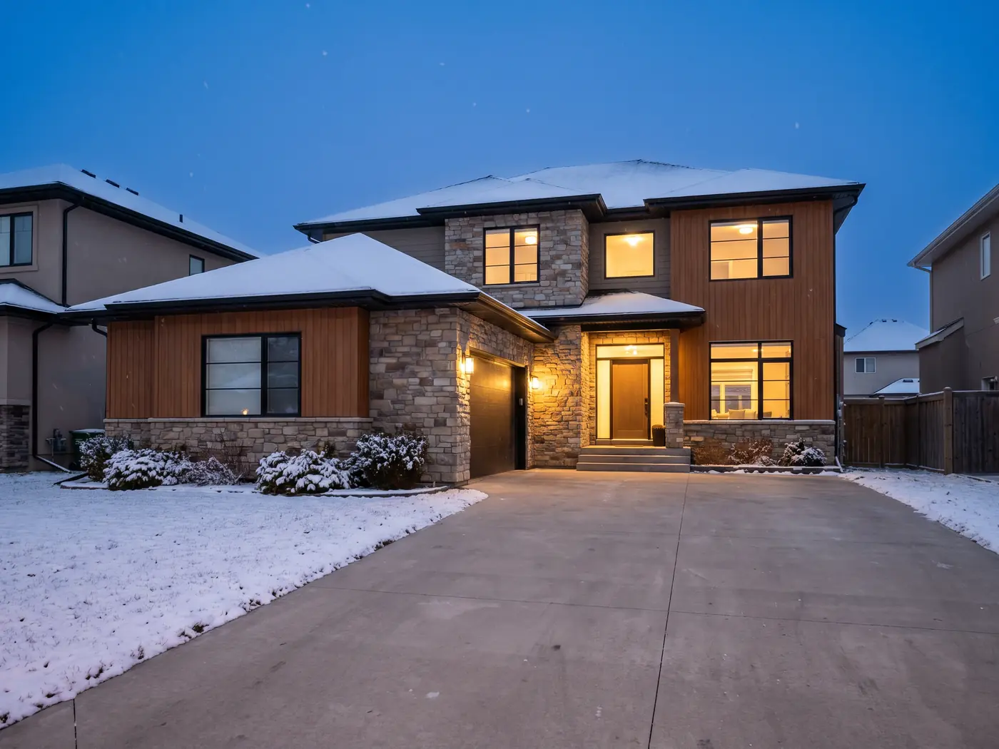Modern Winnipeg home at dusk in light snow